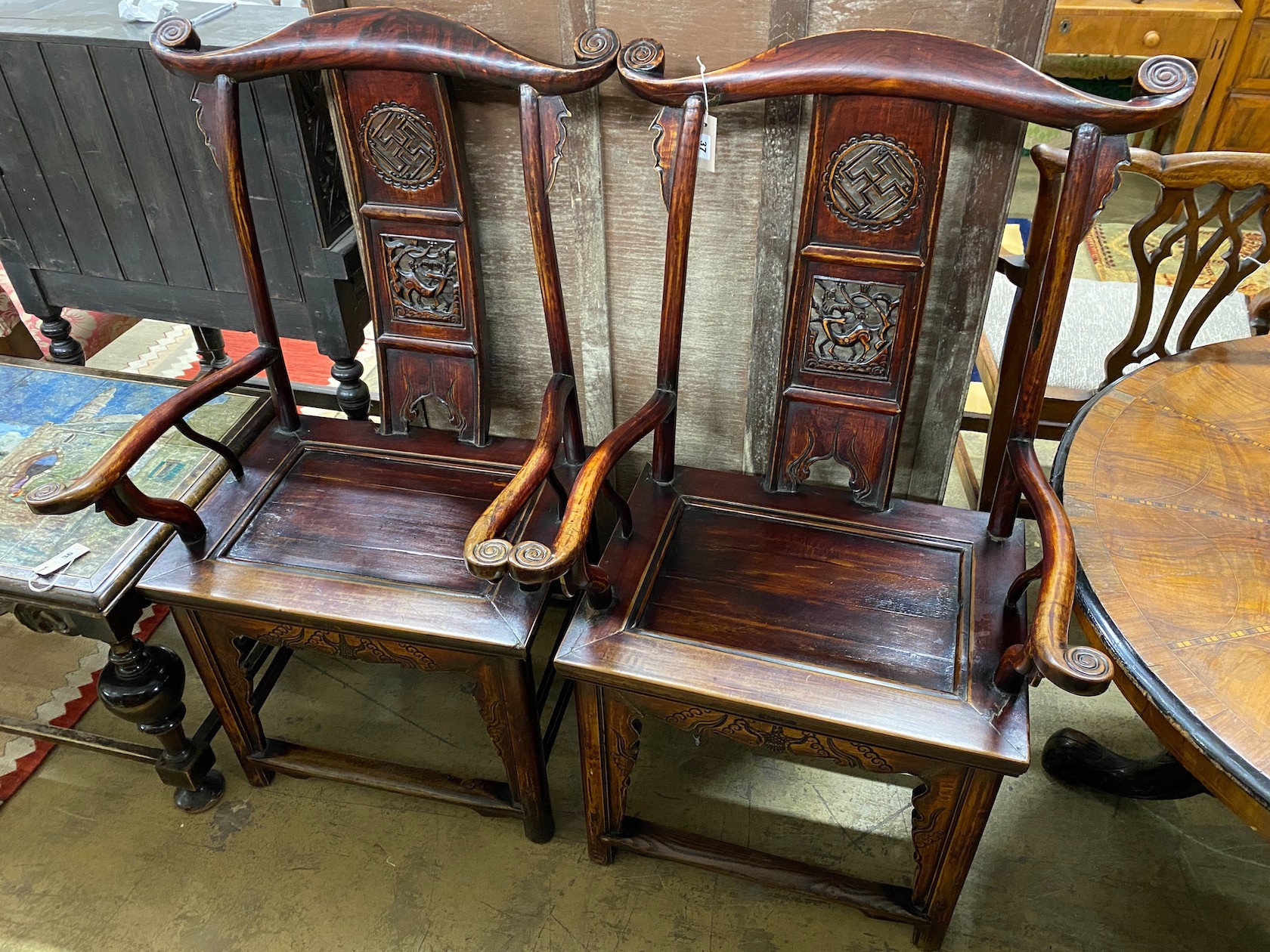 A pair of Chinese elm elbow chairs, width 63cm, depth 50cm, height 118cm